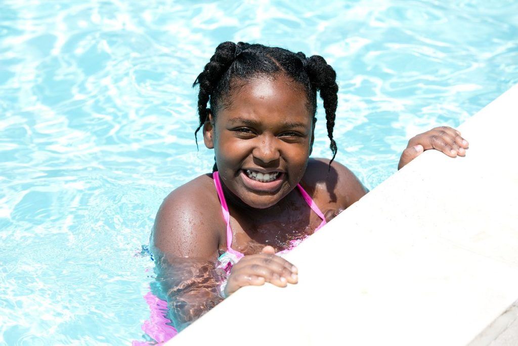 Child smiling at camera while in pool